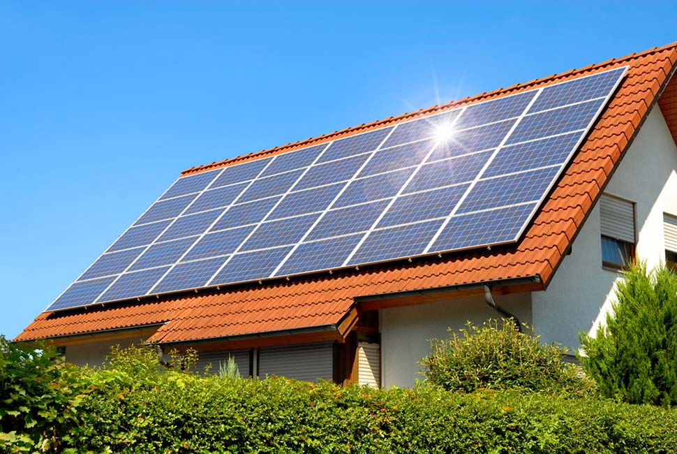 a home with solar panels installed on its red-tiled roof