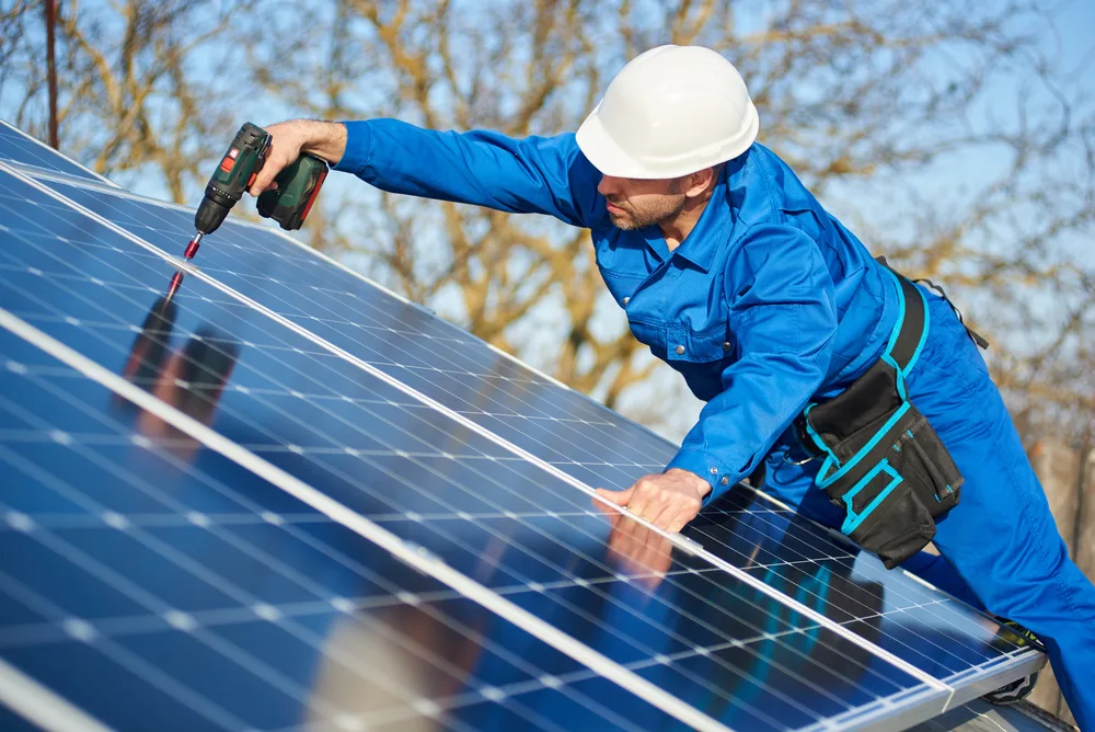 a contractor installing solar panels on a roof