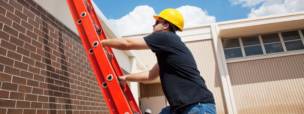 Man climbing on a business roof