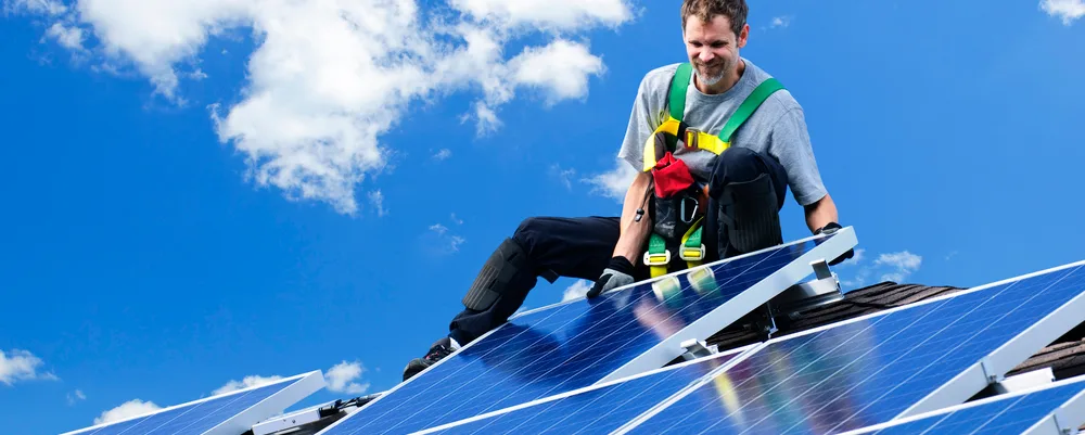 man installing solar panel on cloudy day